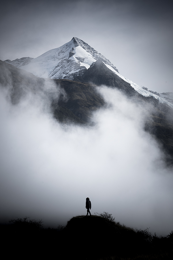 A man standing before a snow covered mountain