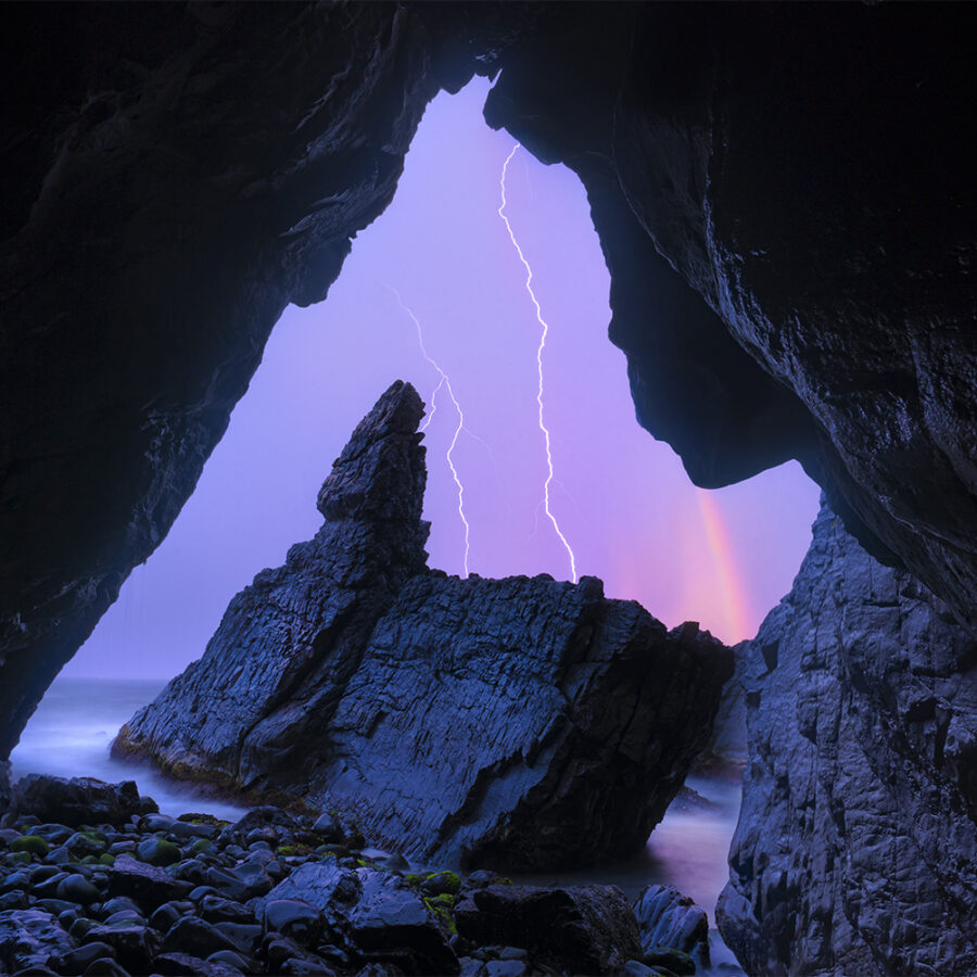 Lightning and rainbow outside a cave