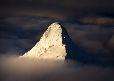 A mountain peak rising above the cloud.