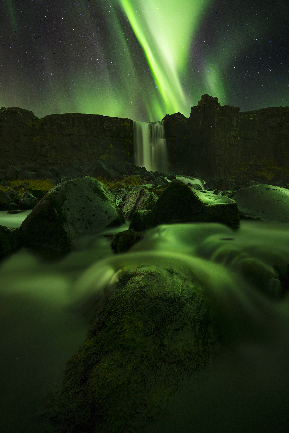 The Northern Lights above a waterfall in Iceland.