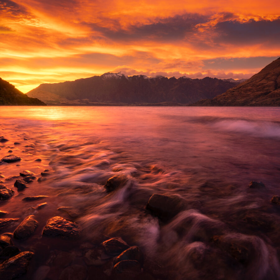 The Remarkables and Lake Wakatipu underneath a colourful sunrise.
