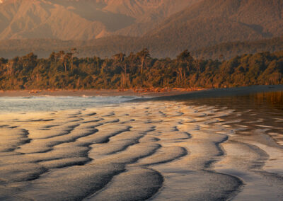 Sand patterns leading to snow capped mountain, New Zealand.